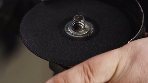 Closeup Man Hand an Angle Grinder Cutting Disc is Changed to Another By Unscrewing Nut Using an Open