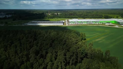 Vista aérea de uma instalação industrial moderna cercada por uma vegetação exuberante que se mistura com relaxante