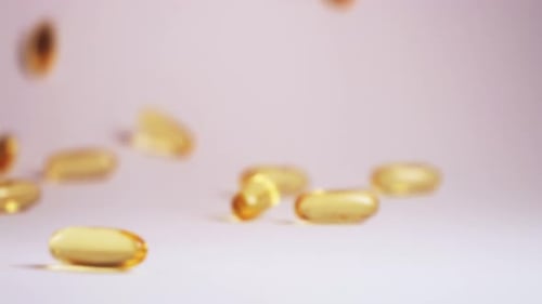 Shiny Golden Gel Capsules Fall in Studio Light