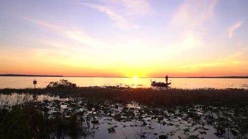 time lapse of a fishermen floating in a boat at sunrise over a lake in Florida 30p 1080p