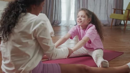 Mother and Little Cute Daughter Doing Stretching Exercises Training Together Cozy Home