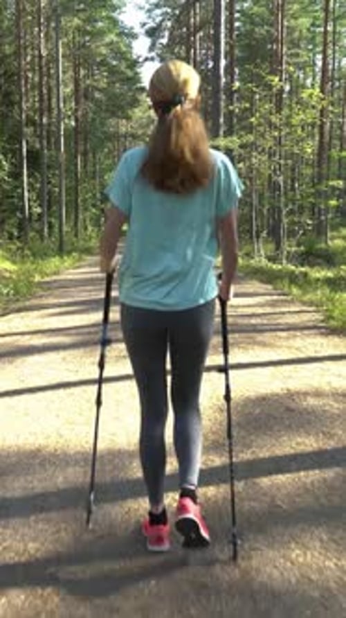Active Woman Doing Nordic Walking in a Park