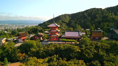 A wide, tracking drone shot of the red buildings of Kioto's world famous Kiyomizu-dera temple and sh