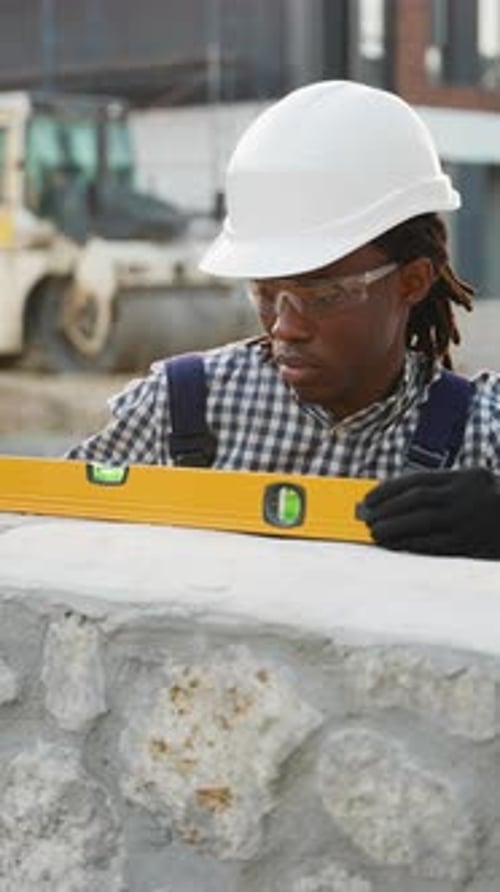 Construction Worker Using Spirit Level on Wall