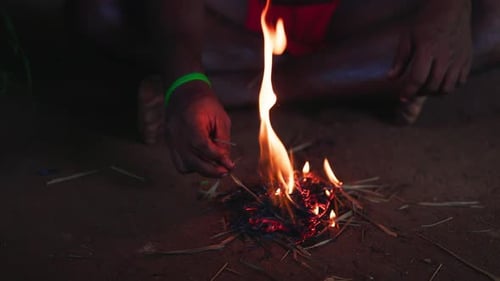 An Aborigine in a Loincloth Makes Fire in the Traditional Way Striking Sparks on Tinder Lighting a