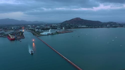 Drone footage of Townsville Port with ship leaving on stormy morning