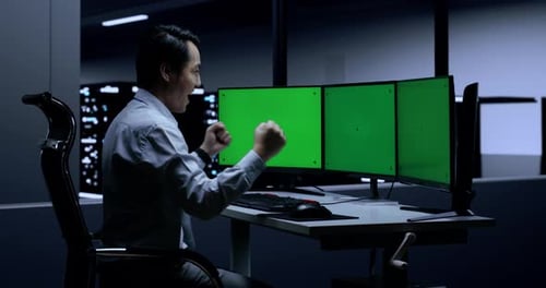 Asian Male Programmer Celebrating Succeed Working On Green Screen Desktops In The Server Room