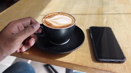 Männer halten eine Kaffeetasse auf dem Tisch