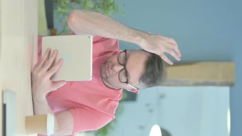 Man Looking at Tablet Device with Surprise