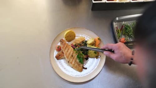 Chef Plates Grilled Fish with Fresh Herbs