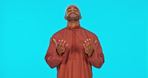 Portrait, muslim or man in studio praying isolated on blue background to worship God