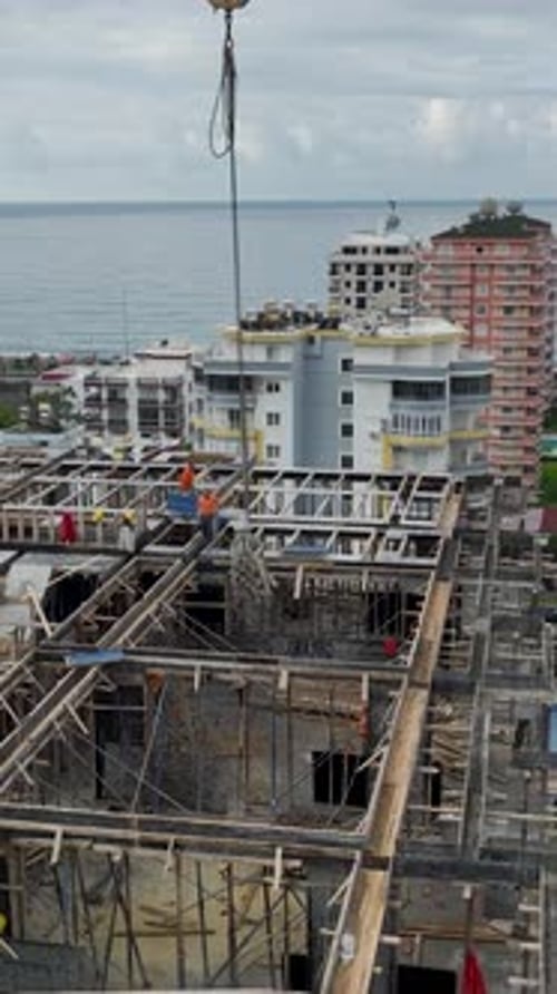 Vertical Video of Crane Delivering Structural Panels to Workers