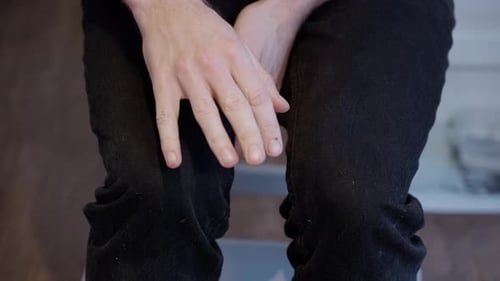 Close-up of Anxious Caucasian Man's Nervous Gestures and Shaking Hands