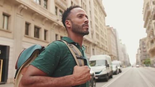 Young man tourist crosses the road at pedestrian crossing