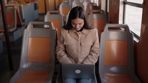 Young Woman Working on Laptop During Ferry Commute