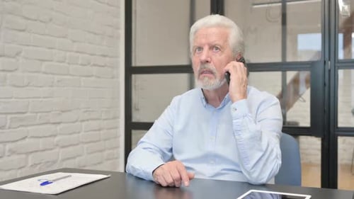 Senior Businessman Talking on phone in Office