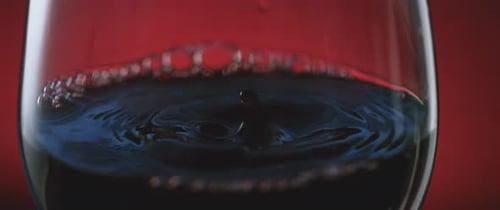 Close Up of Red Wine with Drops Falling