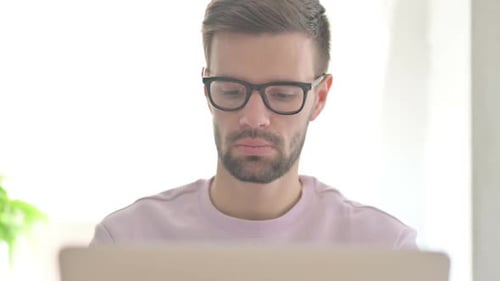Close Up of Young Man Typing on Laptop