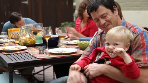 Family Enjoying Outdoor Meal with Young Child