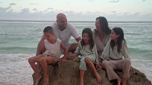 Happy Family of Adult People with Children Sitting at Sea Water of Ocean Beach