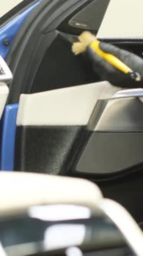 A Man Does Dry Cleaning of the Car Interior Vacuums the Car Interior Vertical Video