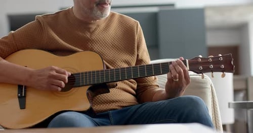 Man Playing Guitar and Singing at Home