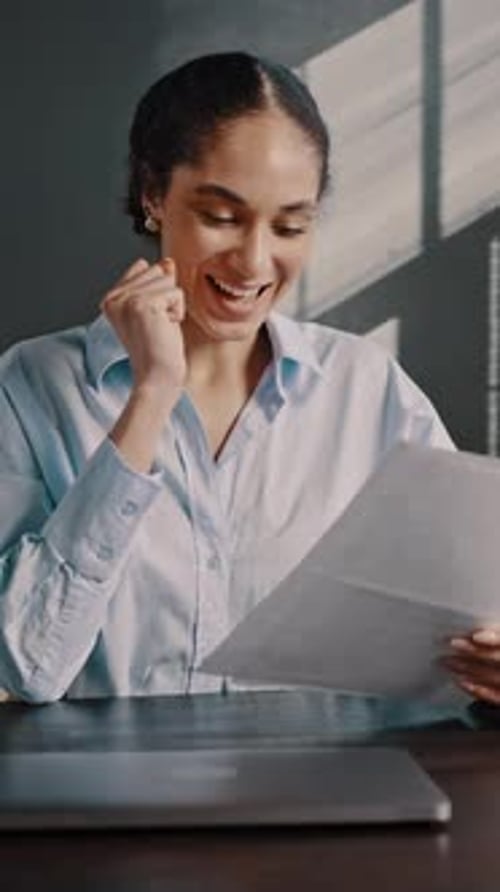 Woman Reads Document and Reacts Positively