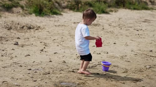 Little child summer lifestyle. Small boy on river beach playing.