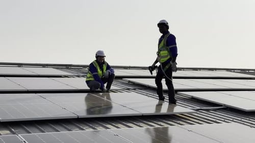 Technician installing solar cell. Installation and maintenance of solar cells on rooftop.