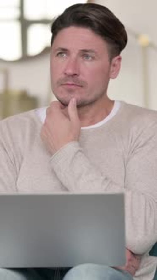 Middle Aged Man Thinking and Working on Laptop , at Home, Vertical Video