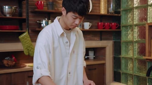 Young Adult Making a Sandwich in Kitchen