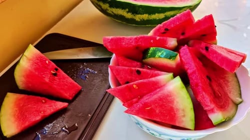 Fresh Sliced Watermelon With Seeds and Knife on Kitchen Table in Daylight