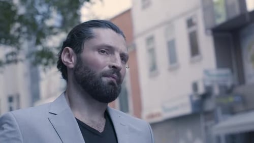 Handsome bearded man in the suit walking on the street in slow motion