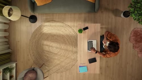 Top View Capturing a Man Working on a Laptop in His Home Office and Drinking Coffee Young Male