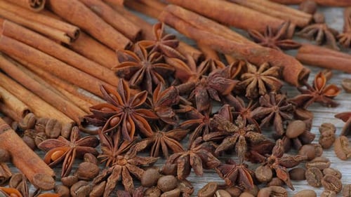 Especias aromáticas con canela, anís estrellado y granos de café sobre mesa de madera