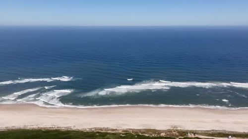 Crashing Ocean Waves Creating a Picturesque Scene on a Sandy Beach