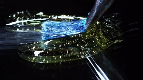 Dramatic paintbrush stroke through gold liquid on black background