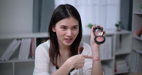 Hermosa bloguera asiática está mostrando cómo maquillar y usar cosméticos