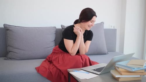 Woman Using Laptop Computer Sitting on Sofa