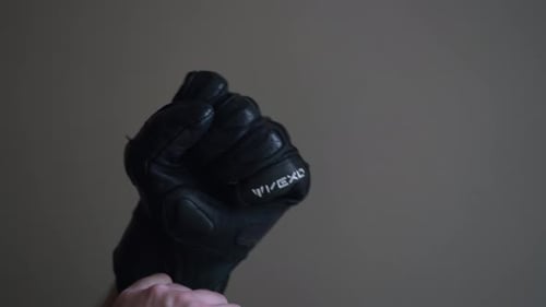 young man puts on and tries on motorcycle gloves and takes them off 4k