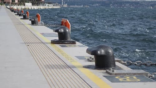 Im Hintergrund sind Hafenpoller am unruhigen Wasser in Küstennähe sichtbar