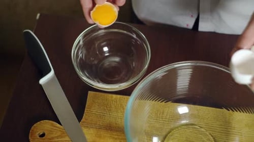 Breaking an Egg into a Clear Glass Bowl