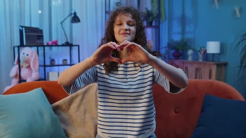 Smiling Woman Making Heart Shape with Hands