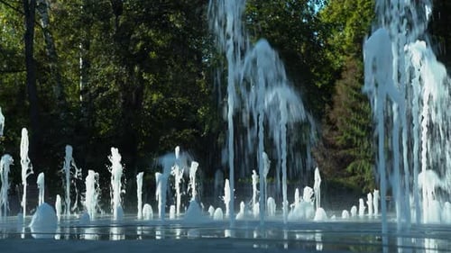 A Summer Fountain In The Park Splashes Among The Trees