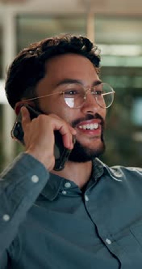 Man in Office Laughing on Smartphone