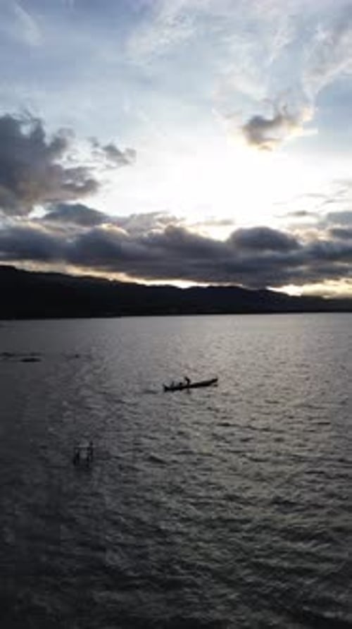 Drone vertical filmé par un pêcheur sur son bateau dans le lac
