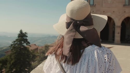 Rear View of Beautiful Female Tourist in a Straw Hat