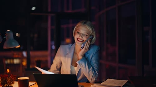 Smiling Woman Working on Laptop at Night
