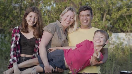 Happy Family Smiling Together Outdoors in Nature