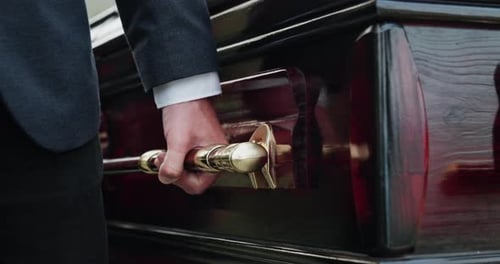 Hand, funeral and man carry coffin for death, memorial service and rest in peace with farewell